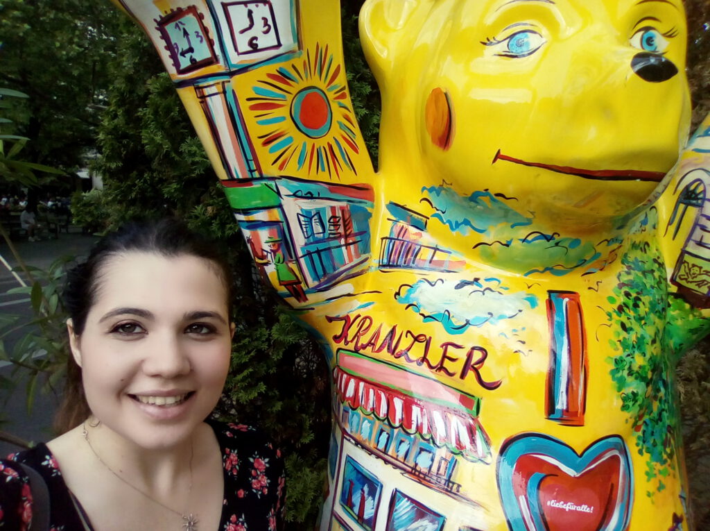 Elena Volpato (Deutsch-Italienisch-Übersetzerin) in Berlin neben einem gelben Bär. 
