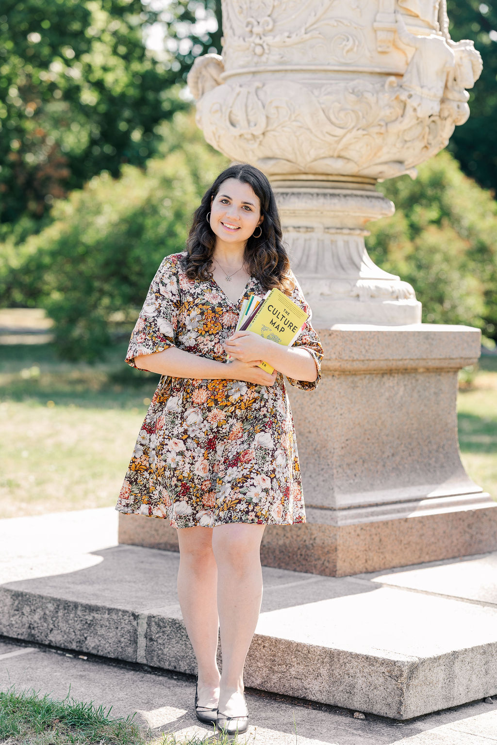 Elena Volpato standing with copywriting book between her arms. A big urn in the background